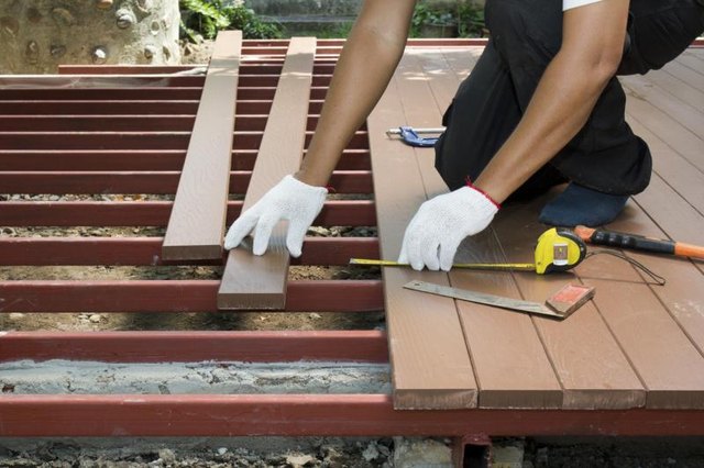A man building a wooden deck