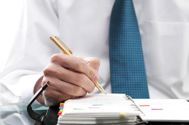 A businessman is writing in his notebook.