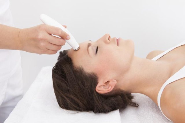 Dermatologist using microdermabrasion tool on client Dermatologist using microdermabrasion tool on client