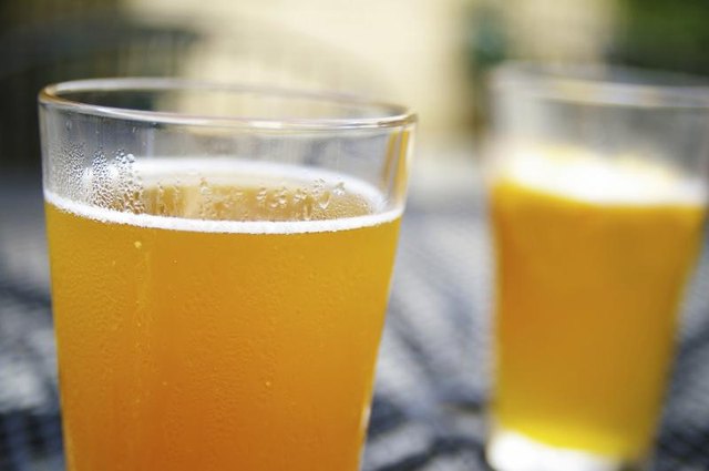 Glasses of beer on a sunny outdoor table.