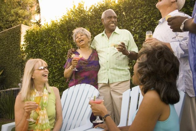 People laughing at a backyard gathering.