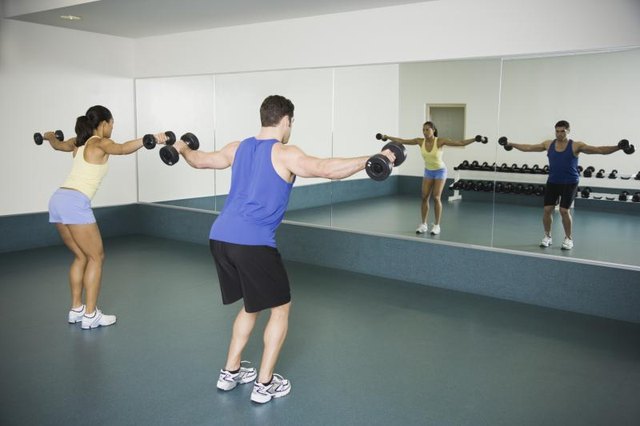 Man and woman lifting weights at the gym
