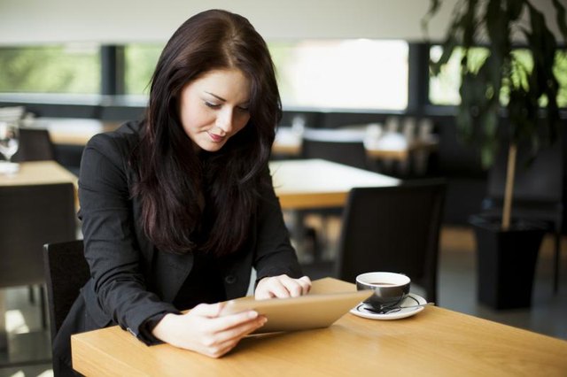 Young female student reading over her essay on a tablet