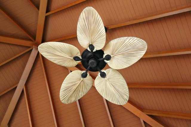 A ceiling fan hanging from a wooden peak.