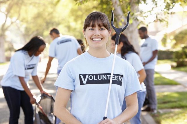 Woman cleaning streets with volunteers