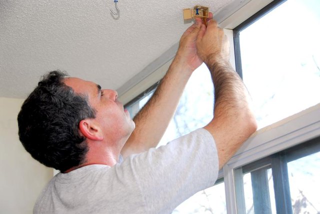 Man installing curtains.