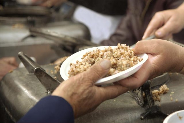 Hands passing out a charity meal.
