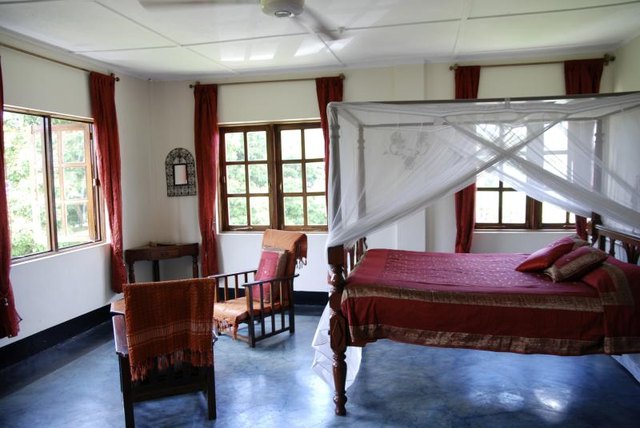 Mosquito netting neatly draped around a canopy bed in a plantation bedroom.