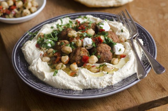 A plate of hummus with falafel and chickpeas.