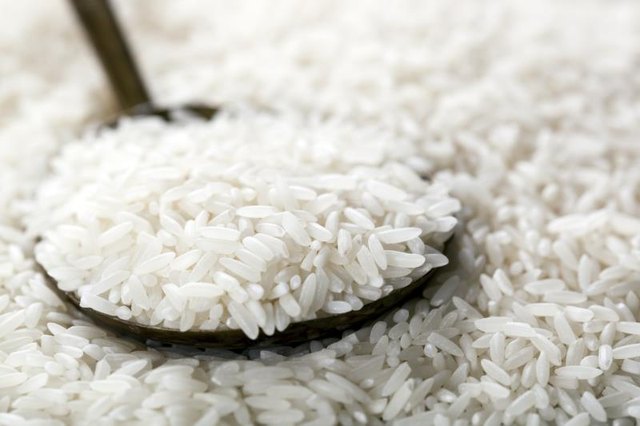 A spoon scooping up some white rice.