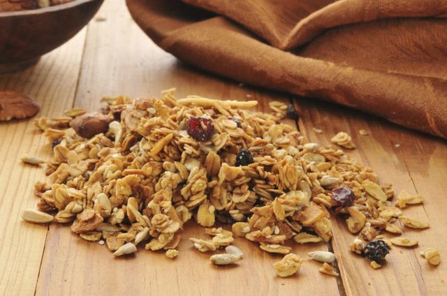 A pile of organic granola on a wood table.