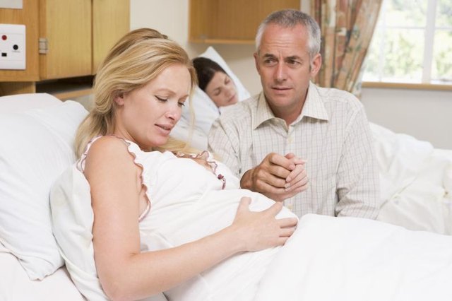 Pregnant woman in labor with husband holding her hand. Pregnant woman in labor with husband holding her hand.