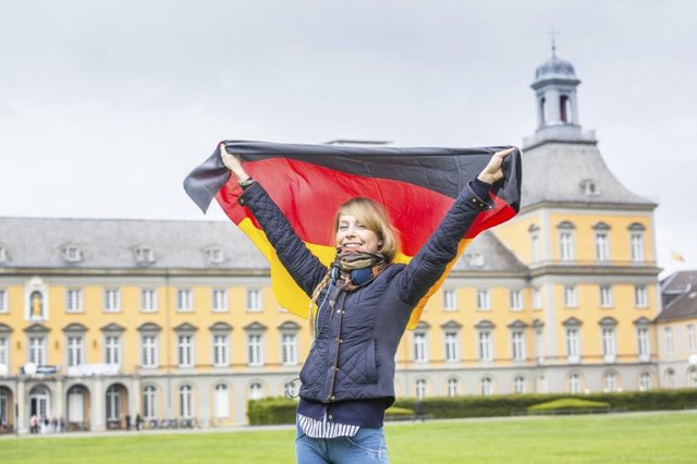 Girl with a German flag in front of Bonn University.