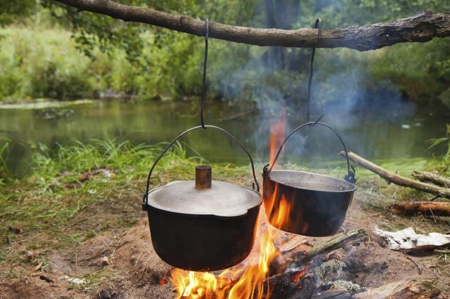 Cooking pots hang over camp fire