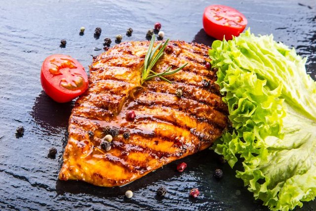 Grilled skinless chicken breast with lettuce, cherry tomatoes, herbs and spices.