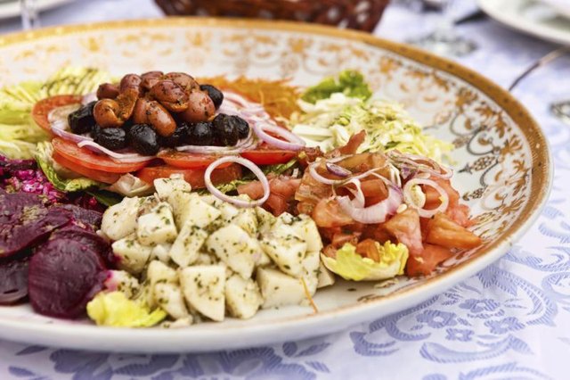 A sample platter of Moroccan dishes on a pretty tablecloth.