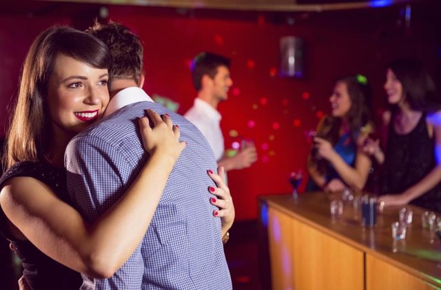 A couple dances at a party.
