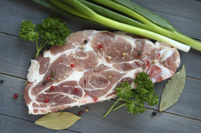 Raw pork shoulder with herbs and spices.