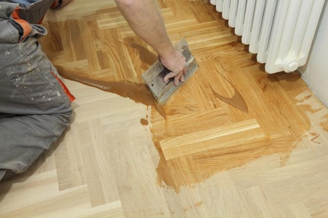 Worker varnishing oak floors