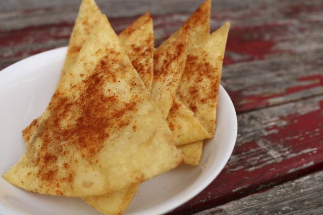 A serving of homemade pita chips sprinkled with cinnamon on an outdoor table.