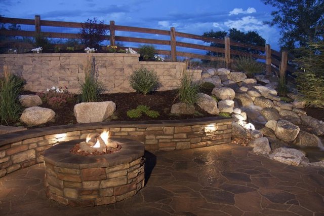 Create tiered landscaping with a retaining wall, stones and a few accent plants.