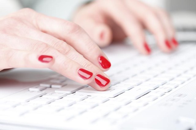 Close-up of hands typing on keyboard