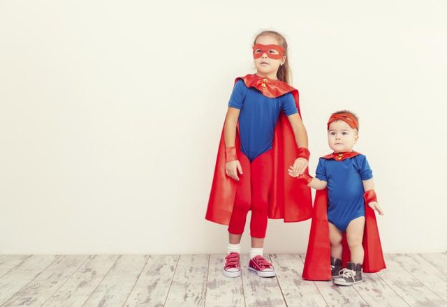 Two siblings dressed up as superheroes.