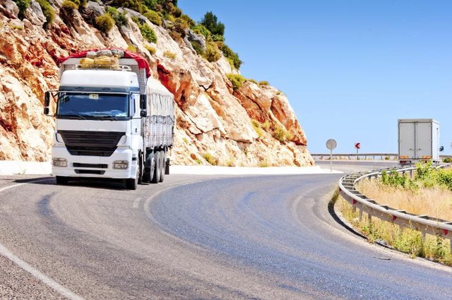 A tractor-trailer turns down a mountain highway.