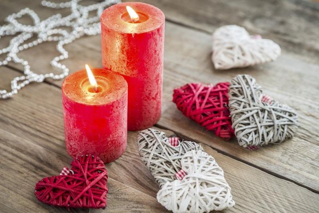 Candles and handmade hearts on a table.