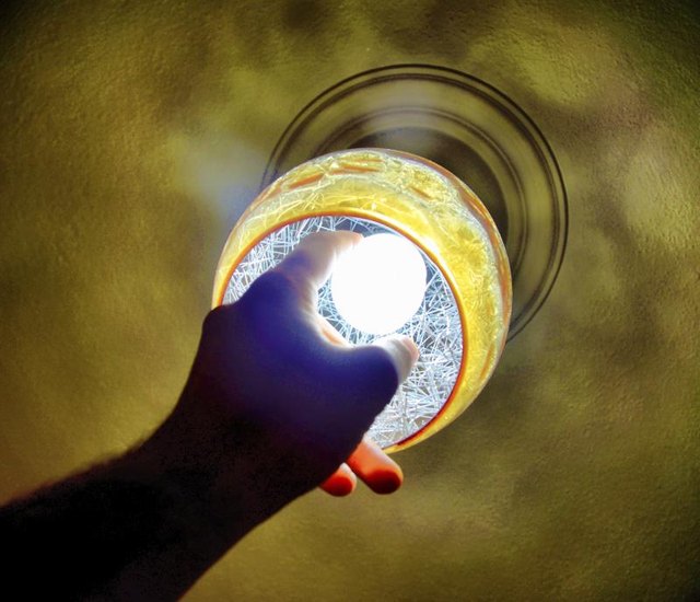 Close-up of man changing a lightbulb