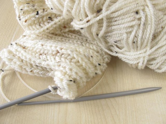 A cream scarf being knitted.