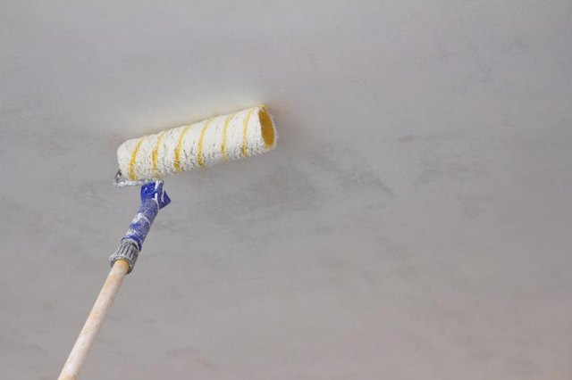 Paint roller painting ceiling.