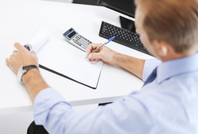 A businessman doing calculations. A businessman doing calculations.
