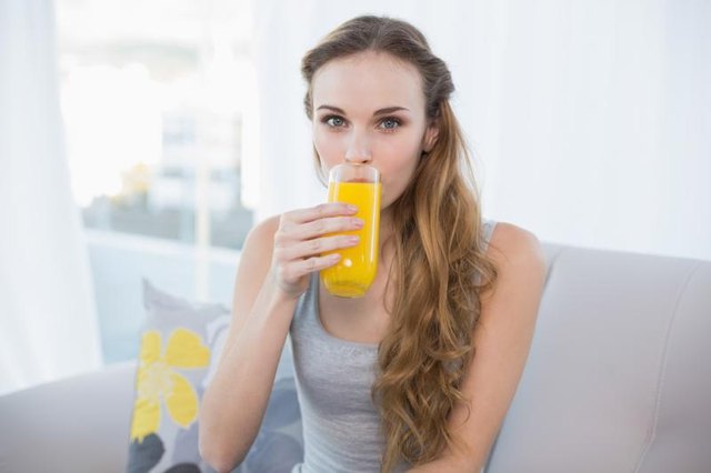 Young woman drinking glass of fruit juice.