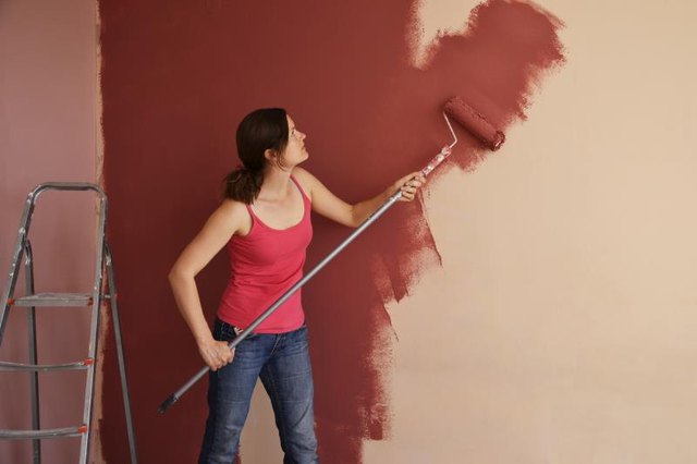 Woman using roller to paint wall
