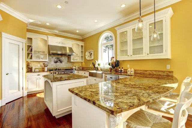 A brightly lit kitchen with several granite countertops