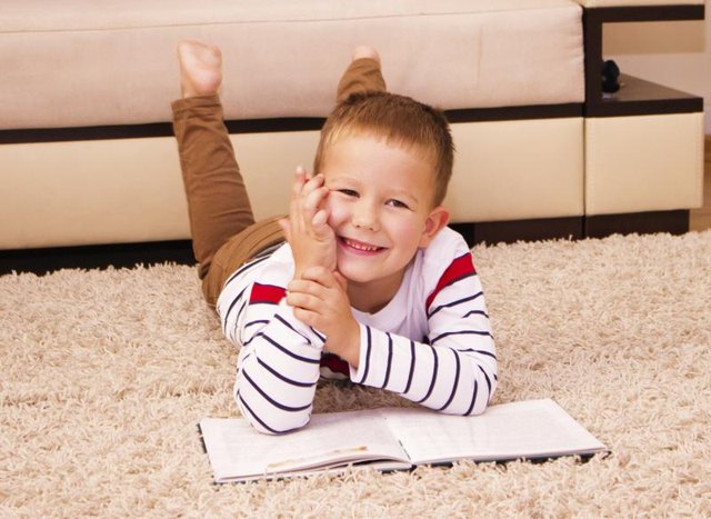 Young student reading from book.