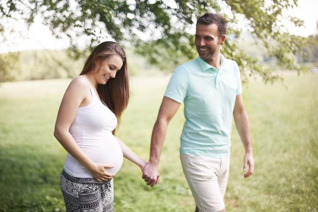 Pregnant woman on walk with her husband.