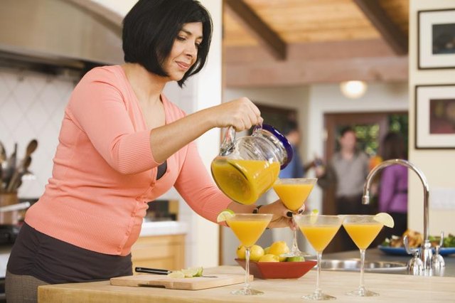 A woman is pouring cocktails.