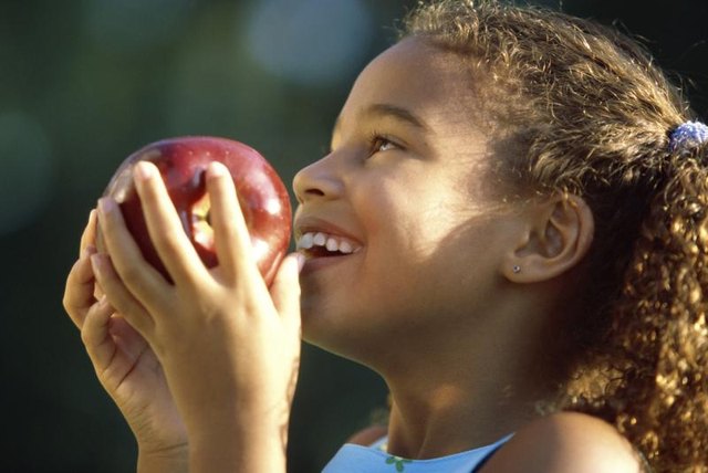 Young girl holding an apple.