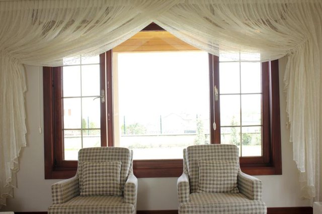 Heavy yet sheer curtains gracing the perimeter of a sitting room window.