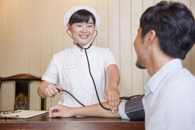 A nurse checking a man's blood pressure.