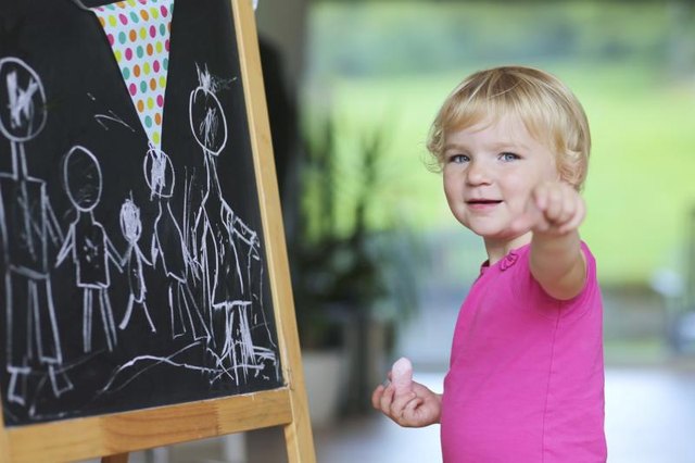 A young child is playing on a chalkboard.