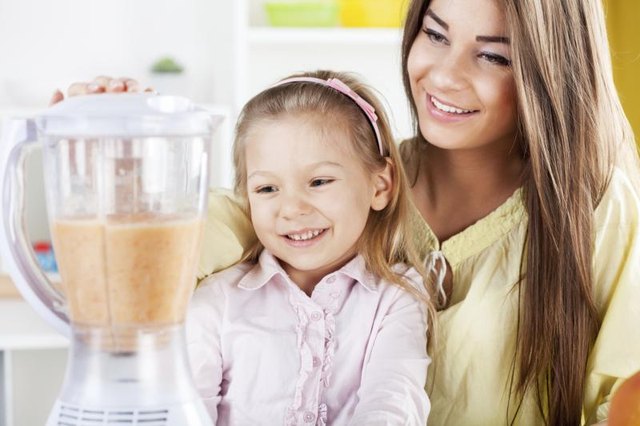 Woman making smoothie in blender.
