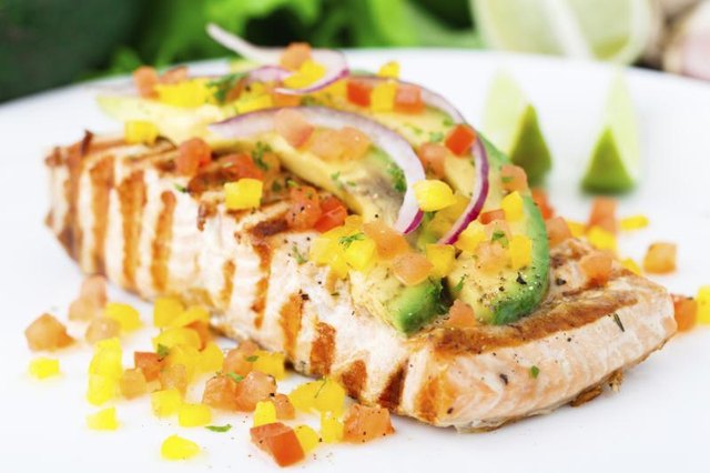 Plate of freshly grilled salmon with avocado salsa on top. Plate of freshly grilled salmon with avocado salsa on top.