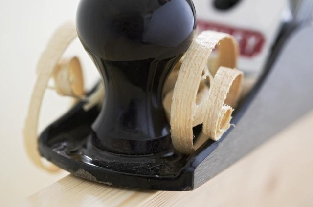 A block plane being used to shave wood.
