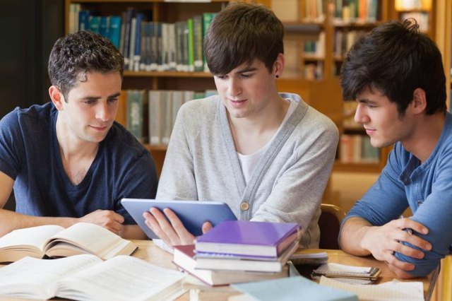 Teenage students researching in the library together.