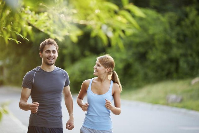 A couple jogs along a country road.