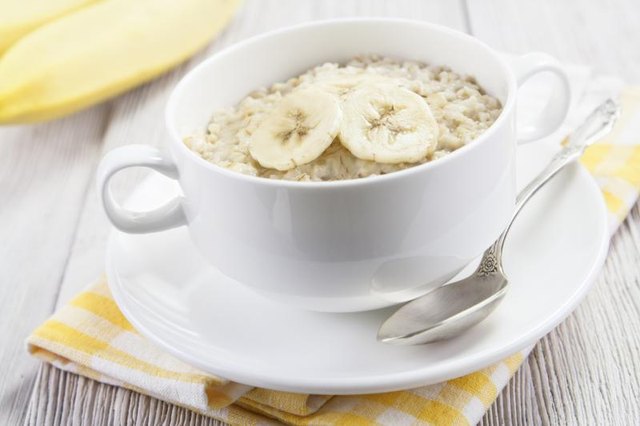 Small bowl of oatmeal with sliced bananas on top.
