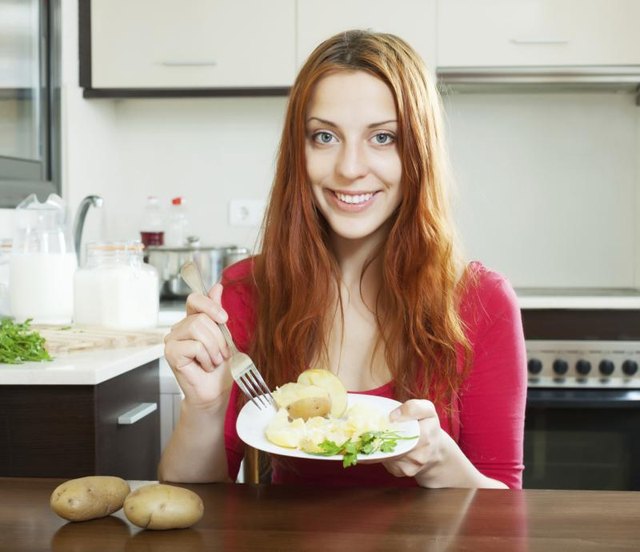 Young woman eating potatoes